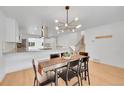 Bright dining room with modern chandelier and a view of the staircase and kitchen at 6498 S Everett Way, Littleton, CO 80123