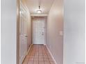 Hallway view featuring tile flooring, a white front door, and a closet door on the left at 2575 S Syracuse Way # 101, Denver, CO 80231