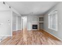 Spacious living room with hardwood floors, fireplace, mantel and large arched window at 2575 S Syracuse Way # 101, Denver, CO 80231
