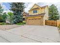 Two-story home featuring a front-facing two-car garage, brick and shingle siding, and lush landscaping at 12319 W Burgundy Ave, Littleton, CO 80127