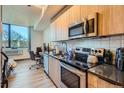 Modern kitchen with stainless steel appliances and wood cabinets at 603 Inca St # 213, Denver, CO 80204