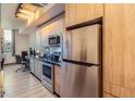 Modern kitchen with stainless steel appliances and wood cabinets at 603 Inca St # 213, Denver, CO 80204