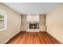 Bright living room with hardwood floors, a fireplace, and built-in bookshelves offers great space at 6427 S Ingalls St, Littleton, CO 80123