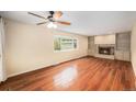 Bright living room with hardwood floors, a fireplace, and built-in bookshelves offers great space at 6427 S Ingalls St, Littleton, CO 80123
