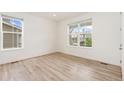 Bright bedroom with large windows, light hardwood floors and neutral colors at 5226 Inland Ave, Firestone, CO 80504