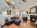 Inviting living room with hardwood floors, a cozy fireplace, and a staircase with iron railings at 11275 Holly St, Thornton, CO 80233