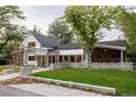 Landscaped front yard featuring a modern home with black framed windows and a covered porch area at 13905 Berry Rd, Golden, CO 80401