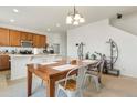 Dining room with a wooden table, four chairs, and access to the kitchen at 334 Feather Pl, Lochbuie, CO 80603