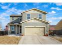 Two-story house with light green exterior, two-car garage, and landscaping at 334 Feather Pl, Lochbuie, CO 80603