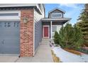 Front entrance with red door, brick columns, and a walkway leading to the porch at 3836 Garnet Way, Highlands Ranch, CO 80126