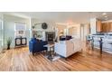 Open-concept living space with hardwood floors and a view into the kitchen at 7938 S Quemoy Way, Aurora, CO 80016