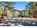 Two-story home featuring a charming green exterior, attached garage, and large driveway at 4185 Red Rock Dr, Larkspur, CO 80118