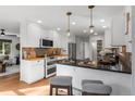 Well-lit kitchen with white cabinets, stainless steel appliances, and a breakfast bar at 4185 Red Rock Dr, Larkspur, CO 80118