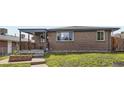 Brick house with covered front porch and healthy green grass at 925 Wolff St, Denver, CO 80204