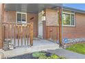 Classic covered front porch with brick accents and a secure entrance at 925 Wolff St, Denver, CO 80204
