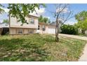 Charming home with manicured lawn and neutral siding, shaded by a mature tree at 19053 E 22Nd Dr, Aurora, CO 80011