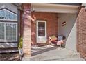 Cozy front porch with brick accents and comfortable seating for relaxing outdoors at 9603 Las Colinas Dr, Lone Tree, CO 80124