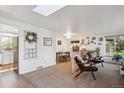 Bright living area features a skylight and open floor plan, seamlessly connects to the dining area and kitchen at 2330 Yarrow St, Lakewood, CO 80214
