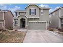 Inviting two-story home featuring a two car garage, an arched entryway, and tasteful landscaping at 1432 Red Mica Way, Monument, CO 80132