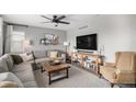 Comfortable living room featuring a cozy sectional sofa, ceiling fan, and neutral decor at 1432 Red Mica Way, Monument, CO 80132