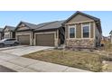 Charming home featuring a two-car garage, stone accents, and well-maintained landscaping at 6712 Sea Oats Dr, Parker, CO 80138