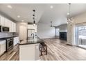 Open-concept kitchen with granite countertops, stainless steel appliances, and modern lighting fixtures at 6712 Sea Oats Dr, Parker, CO 80138