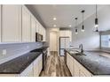 Modern kitchen featuring granite countertops, stainless steel appliances, and ample cabinet space at 6712 Sea Oats Dr, Parker, CO 80138