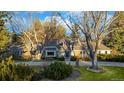 Charming brick home with a meticulously landscaped front yard and mature trees in daytime at 3990 S Hudson Way, Cherry Hills Village, CO 80113