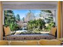 Comfortable window seat with decorative pillows and a view of the green and lush backyard at 3990 S Hudson Way, Cherry Hills Village, CO 80113