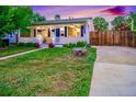 Charming home with a cozy front porch, wood fence, and inviting curb appeal at 2530 S Knox Ct, Denver, CO 80219