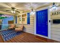 Inviting front porch with seating area, blue door and decorative lighting at 2530 S Knox Ct, Denver, CO 80219