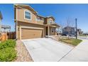 Two-story home with a concrete driveway and partially xeriscaped front yard at 261 Mesa Ave, Lochbuie, CO 80603