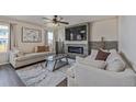 Comfortable living room featuring a stone accent wall with an electric fireplace and a ceiling fan at 261 Mesa Ave, Lochbuie, CO 80603
