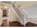 Elegant foyer showcasing a staircase with decorative iron railings and hardwood floors leading to the living area at 16273 E Prentice Pl, Centennial, CO 80015