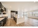Modern kitchen featuring stainless steel appliances, a center island, and beautiful hardwood floors at 2924 S Poppy St, Morrison, CO 80465