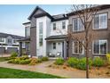 A modern townhome featuring a mix of textures, neat landscaping, and inviting front patio seating at 9305 S Gore St # C, Arvada, CO 80007