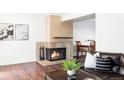 Inviting living room featuring a classic brick fireplace and hardwood floors at 3820 S Fraser St, Aurora, CO 80014