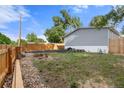 A view of the backyard features grass and gravel with a wood fence at 811 Plum N Ave, Lochbuie, CO 80603