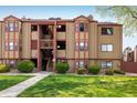 Exterior view of a tan apartment building with red trim, showcasing its well-maintained facade at 8770 Corona St # 101, Denver, CO 80229