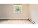 Bright bedroom featuring a window with outdoor views and light wood flooring at 2160 S Vaughn Way # 104C, Aurora, CO 80014