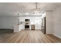 A spacious kitchen features stainless appliances, white cabinets, and a large island, all illuminated by modern lighting at 625 S Alton Way # 3A, Denver, CO 80247