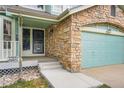 Close-up of home entrance showing stone detail, door, and a two-car garage at 5362 S Danube Ct, Centennial, CO 80015