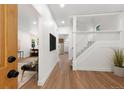 Bright hallway featuring wood floors, white walls, and a staircase with white banisters at 2849 N Vine St, Denver, CO 80205