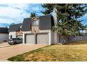Townhome with brick and stone details, a two-car garage, and a nicely landscaped lawn in a residential neighborhood at 5865 E Ithaca Pl, Denver, CO 80237