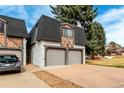 Townhome exterior featuring stone accents, a two-car garage, and a well-kept driveway in a residential area at 5865 E Ithaca Pl, Denver, CO 80237