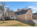 Charming house with neat front yard, attached garage, and cozy design elements under a blue sky at 13040 W 63Rd Pl # C, Arvada, CO 80004