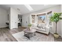 Living room with large windows, modern furniture, with kitchen and front door in the background at 13040 W 63Rd Pl # C, Arvada, CO 80004