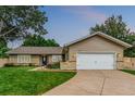 Charming home with a well-manicured lawn, blue front door, and a two-car garage at 7719 S Jackson Cir, Centennial, CO 80122