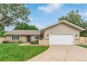 Charming home with a well-manicured lawn, blue front door, and a two-car garage at 7719 S Jackson Cir, Centennial, CO 80122