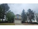 Charming two-story home with stone accents, lush trees, and an attached two-car garage at 18531 E Tanforan Pl, Aurora, CO 80015